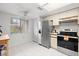 Well-lit kitchen with white cabinets, stainless steel refrigerator, and a window offering a bright view at 4224 Madeira Ct # 3309, Sarasota, FL 34233
