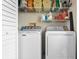 Practical laundry room with full size washer and dryer and shelving for supplies at 4224 Madeira Ct # 3309, Sarasota, FL 34233