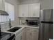 Bright kitchen featuring white cabinets, stainless steel appliances, updated counter tops, and a modern faucet at 5925 Todd St # D-21, Bradenton, FL 34207
