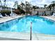 Sparkling community pool surrounded by lounge chairs and lush tropical landscaping, perfect for relaxation at 5925 Todd St # D-21, Bradenton, FL 34207