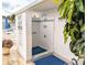 Outdoor shower stall at the community pool featuring white tile, blue mats, and stainless steel fixtures for rinsing off at 5925 Todd St # D-21, Bradenton, FL 34207