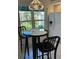 Cozy breakfast nook with black bar stools and a view of the lush greenery outside the window at 5956 Clubside Dr # 7651, Sarasota, FL 34243