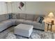 Cozy living room features a large gray sectional sofa with patterned pillows and an ottoman at 5956 Clubside Dr # 7651, Sarasota, FL 34243