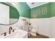 Stylish powder room with green walls, white vanity, and modern fixtures at 3360 Chestertown Loop, Bradenton, FL 34211