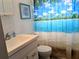 Clean bathroom with a white vanity and beach-themed shower curtain at 5925 Todd St # D-21, Bradenton, FL 34207