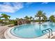 Relaxing resort-style pool with a waterfall feature and palm trees at 14480 Eagle Branch Dr, Nokomis, FL 34275