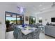 Open concept dining room with white table, patterned chairs and view into the living room at 14480 Eagle Branch Dr, Nokomis, FL 34275
