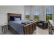 Bedroom with wood bed frame, window seating, and neutral decor at 14480 Eagle Branch Dr, Nokomis, FL 34275