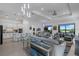Open concept living and kitchen area, featuring grey sofas and white kitchen cabinets at 14480 Eagle Branch Dr, Nokomis, FL 34275