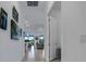 Bright hallway with tile floors, leading to living areas and featuring framed wall art at 14480 Eagle Branch Dr, Nokomis, FL 34275