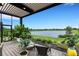 Relaxing covered patio overlooking a lake with wicker furniture at 14480 Eagle Branch Dr, Nokomis, FL 34275