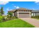 Exterior of a single-story house with a two-car garage and landscaped yard at 3118 Tramonto Ct, Bradenton, FL 34211