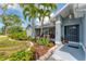 Inviting home exterior with meticulously landscaped garden beds, palm trees, and a covered entryway at 5306 19Th W Ave, Bradenton, FL 34209