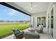 Inviting covered patio with comfortable seating, ceiling fan, and serene view of lake and greenery at 9018 Sunray Cv, Parrish, FL 34219