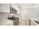 Modern kitchen features stainless steel appliances and gray backsplash at 220 Capriana Ct, Nokomis, FL 34275