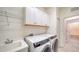 Bright laundry room with washer, dryer, and extra storage at 220 Capriana Ct, Nokomis, FL 34275