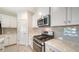 Modern kitchen with stainless steel appliances and gray tile backsplash at 220 Capriana Ct, Nokomis, FL 34275