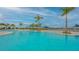 Resort-style pool with palm trees and shaded seating areas at 9018 Sunray Cv, Parrish, FL 34219