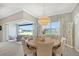 Elegant dining room with round table, neutral decor, and backyard access at 9018 Sunray Cv, Parrish, FL 34219