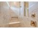 Elegant shower with marble tile, built-in seat, and window at 9018 Sunray Cv, Parrish, FL 34219