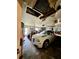 Garage with damaged ceiling, car, and various items at 361 Porpoise Rd, Venice, FL 34293