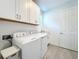 Bright laundry room with washer, dryer, and cabinets at 341 Villoresi Blvd, Nokomis, FL 34275