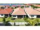 Aerial view of houses with red tile roofs, situated around a lake at 341 Villoresi Blvd, Nokomis, FL 34275