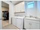 Laundry room with washer, dryer, cabinets, and closet access at 341 Villoresi Blvd, Nokomis, FL 34275