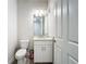 Small bathroom with white vanity, granite countertop, and a toilet at 341 Villoresi Blvd, Nokomis, FL 34275