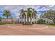 Grand clubhouse exterior, featuring a circular driveway and palm trees at 13 Bayhead Ln, Osprey, FL 34229