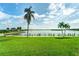 Scenic waterfront view with lush lawn and palm trees at 8911 Midnight Pass Rd # 110, Sarasota, FL 34242