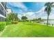 Lush green lawn and tropical landscaping with water views at 8911 Midnight Pass Rd # 110, Sarasota, FL 34242