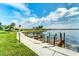 Concrete walkway along the waterfront with wooden docks at 8911 Midnight Pass Rd # 110, Sarasota, FL 34242