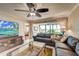 Bright living room with water views, leather sectional sofa, and large TV at 8911 Midnight Pass Rd # 110, Sarasota, FL 34242