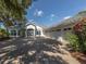 White two-story house with three-car garage and lush landscaping at 2085 Sandhill Ln, Nokomis, FL 34275