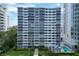 View of a condo building featuring a meticulously landscaped yard, a refreshing pool, and ample lounging space at 555 S Gulfstream Ave # 804, Sarasota, FL 34236