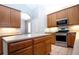 Island kitchen with stainless steel appliances and wood cabinets at 13814 Nighthawk Ter, Lakewood Ranch, FL 34202