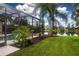 Landscaped backyard with pool and spa, screened enclosure, and lake view at 13814 Nighthawk Ter, Lakewood Ranch, FL 34202