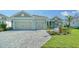 Two-car garage home with paver driveway and landscaping at 21281 Holmes Cir, Venice, FL 34293