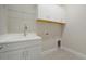 Laundry room with white cabinets, a utility sink, and overhead storage at 21281 Holmes Cir, Venice, FL 34293