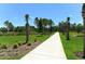 Landscaped walking path with benches, lush greenery, and palm trees at 21281 Holmes Cir, Venice, FL 34293