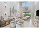 Elegant living room with high ceilings, neutral decor, and access to a patio at 15037 Shady Palms Ln, Nokomis, FL 34275
