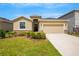 Tan house with stone accents, two-car garage, and manicured lawn at 12354 Nantahala Run, Parrish, FL 34219