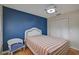 Bedroom with white wicker furniture and blue accent wall at 1026 Bird Bay Way # 276, Venice, FL 34285