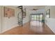 Bright living room with a spiral staircase, wood floors, fan, and a view to the outside from the balcony at 1026 Bird Bay Way # 276, Venice, FL 34285