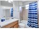 Clean bathroom with a shower/tub combo and blue striped shower curtain at 9019 Heritage Sound Dr, Bradenton, FL 34212