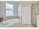Oval garden bathtub, walk-in shower, and linen closet in this bathroom at 9019 Heritage Sound Dr, Bradenton, FL 34212