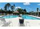 Community pool with shaded seating areas and comfortable loungers at 12420 Destin Loop, Venice, FL 34293