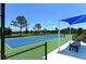 Blue tennis court with a shaded seating area at 12420 Destin Loop, Venice, FL 34293