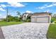 House exterior with a paver driveway and lush landscaping at 14219 Wenzel Ave, Port Charlotte, FL 33981